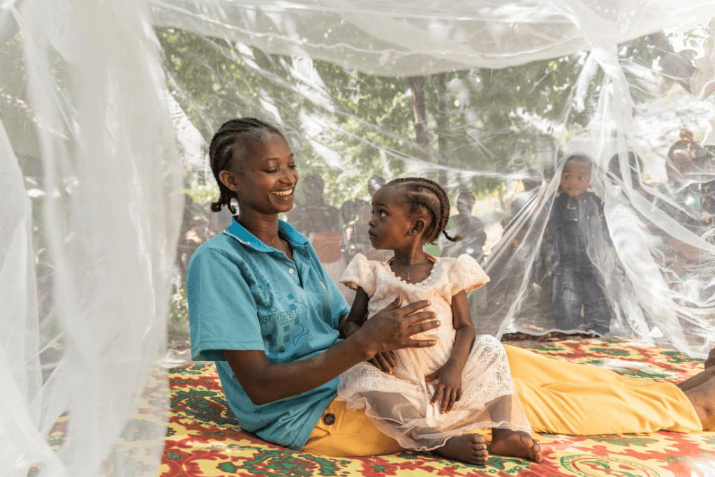Mother, Ayelech and daughter Beti, 2, Ethiopia, under a mosquito net.