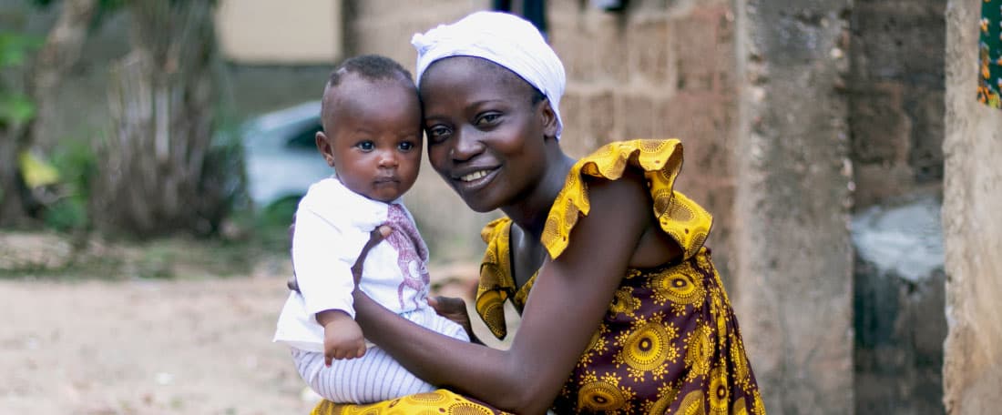 Mokpokpo smiles holding her baby Ayikoe