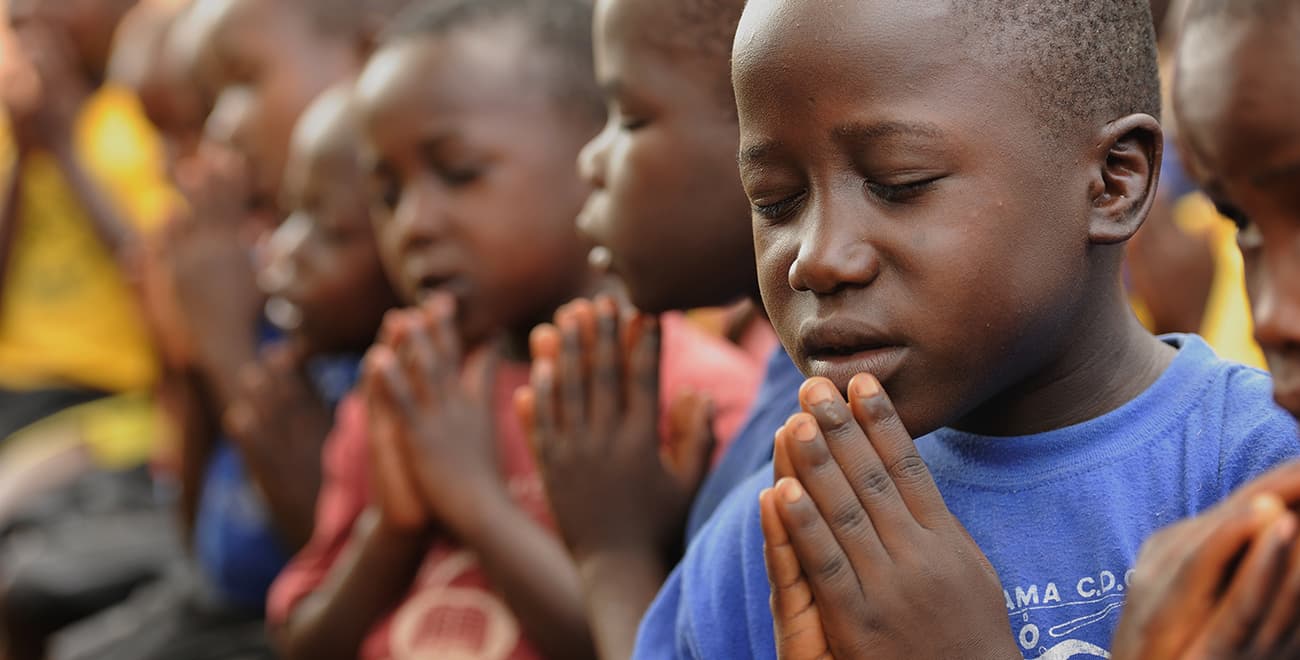 Boys praying in Uganda