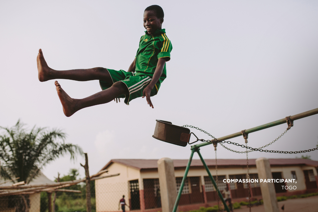 A Compassion participant plays on a swing in Togo