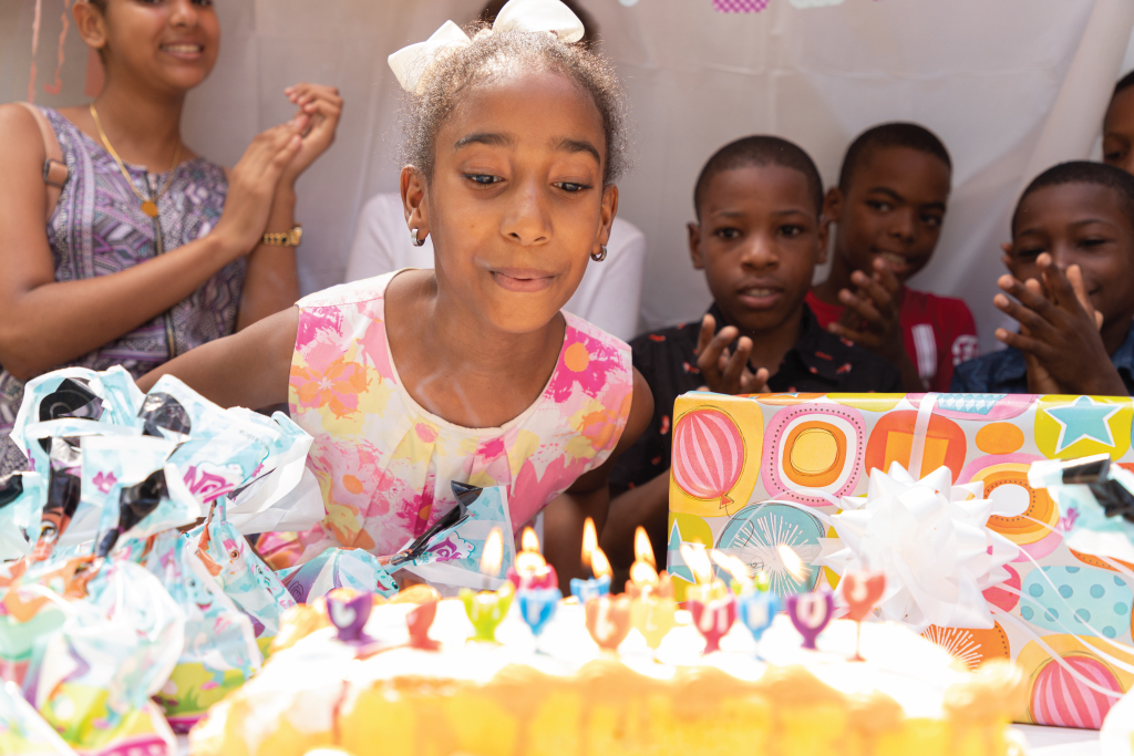 girl blowing out birthday cake candles