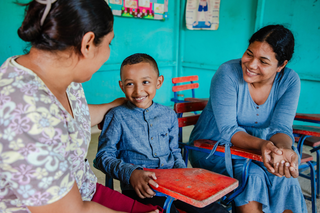 Angell, pictured with his tutor, Tania (left) and his mother, Angela (right)