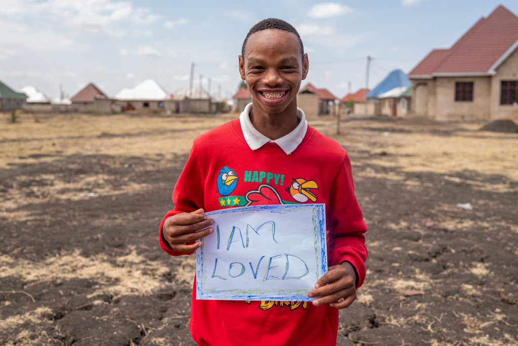 Noel with an I am loved banner at his project