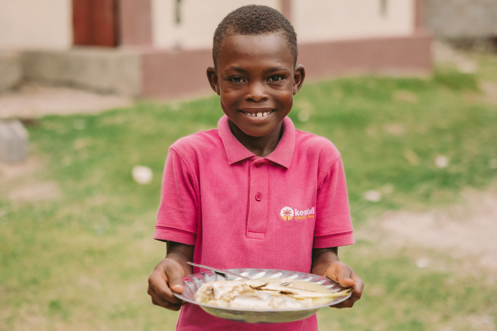 Fawen in Haiti with the food he received at his project