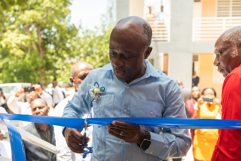 National Director of Compassion Haiti, Guilbaud, cuts the ribbon at the opening ceremony for the centre