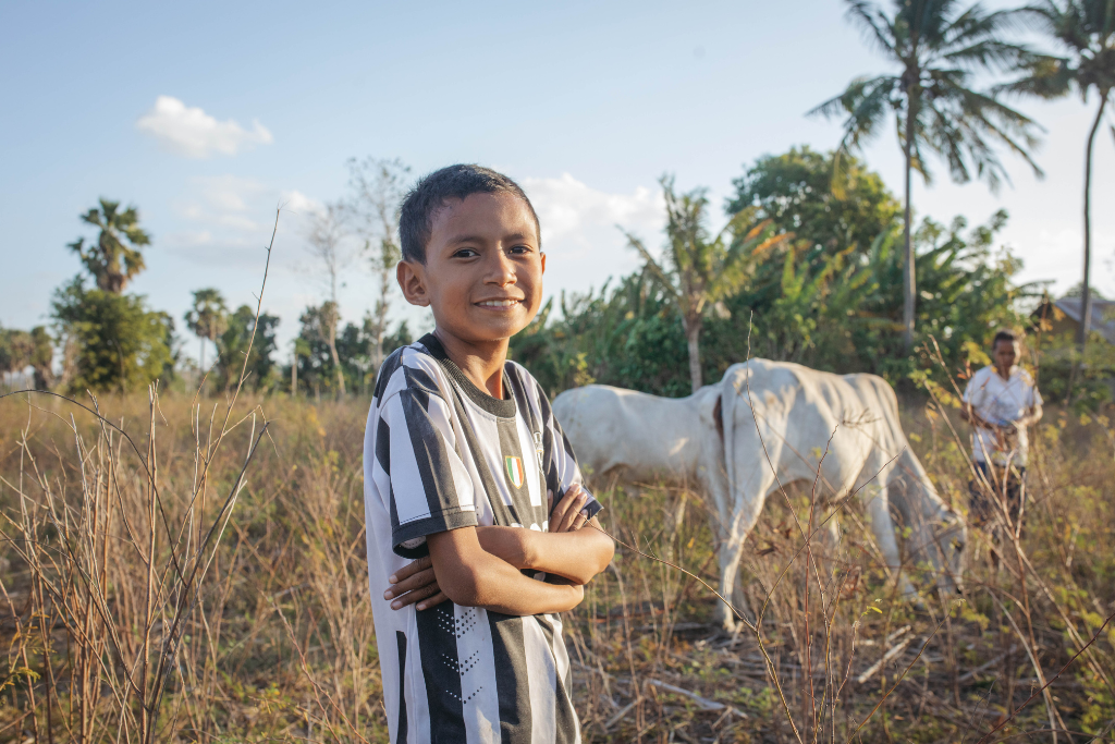 Aren smiles in a field, wearing a football jersey